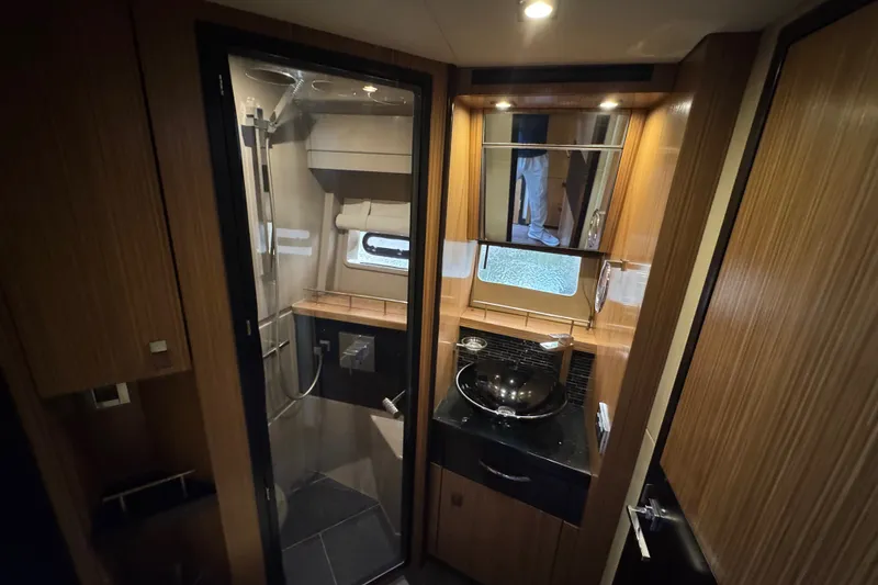 Slide: The Image of Luxurious bathroom interior of 2016 Sea Ray L590 yacht with modern fixtures and wood accents. - 27