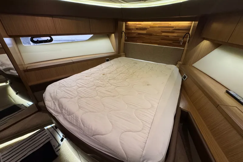 Slide: The Image of Luxurious cabin interior of 2016 Sea Ray L590 yacht with cozy bed and wooden accents. - 29