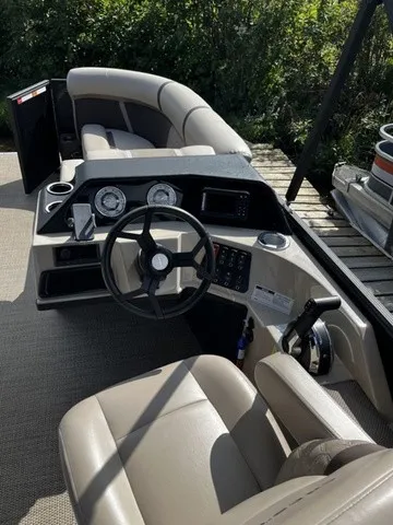 Slide: The Image of The image shows the cockpit of a Crest Classic 200 SLC Pontoon boat with gray upholstery. - 8