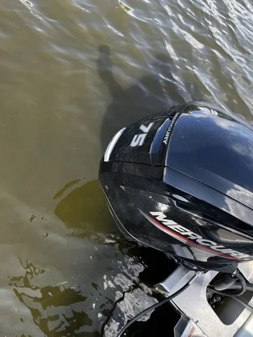 Slide: The Image of A Mercury outboard motor partially visible in the water, surrounded by reflective water. - 19