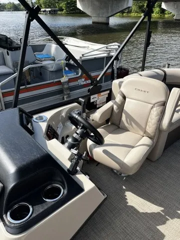 Slide: The Image of The image shows the cockpit of a Crest Classic 200 SLC Pontoon boat with a beige seat. - 6