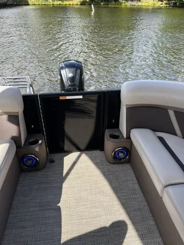 Slide: The Image of The image shows the rear of a 2025 Crest Classic 200 SLC Pontoon boat on calm water. - 16