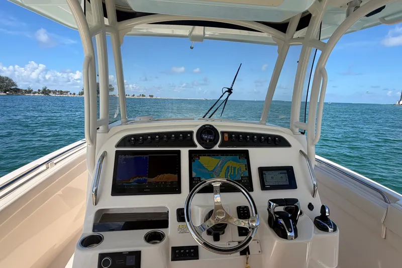 Slide: The Image of 2021 Grady-White Canyon 326 boat dashboard with navigation screens on open water. - 64