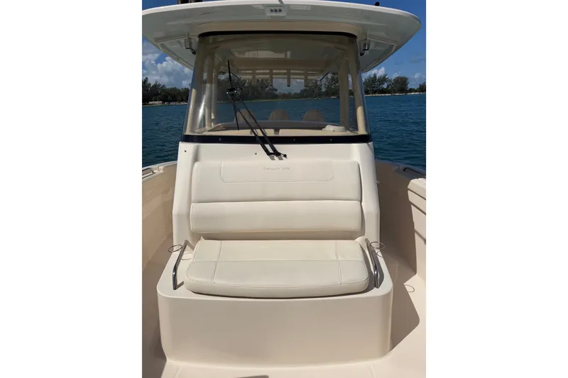 Slide: The Image of 2021 Grady-White Canyon 326 boat with cushioned seating, on calm blue water. - 42