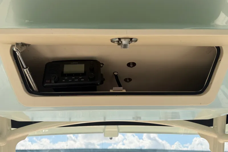 Slide: The Image of Storage compartment with radio equipment on a 2021 Grady-White Canyon 326 boat. - 73