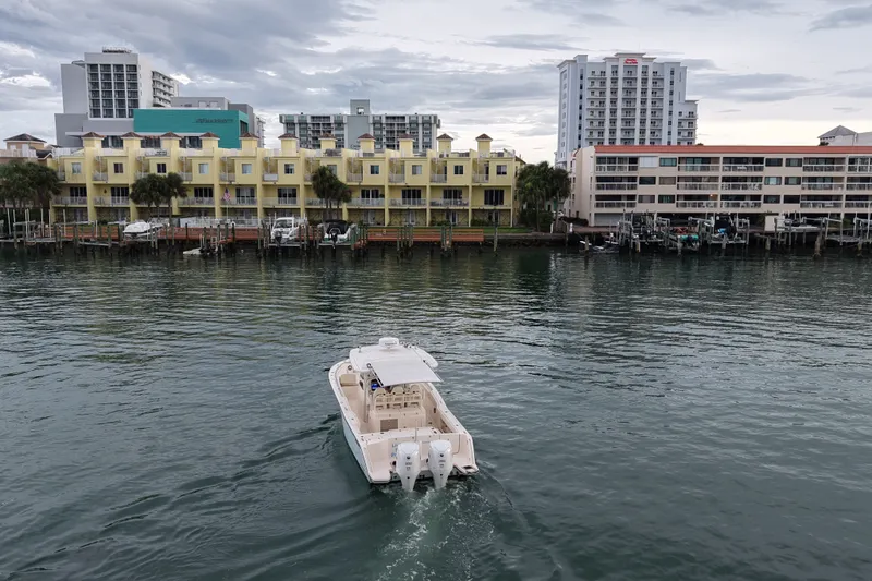 Slide: The Image of 2021 Grady-White Canyon 326 boat cruising near waterfront buildings. - 30