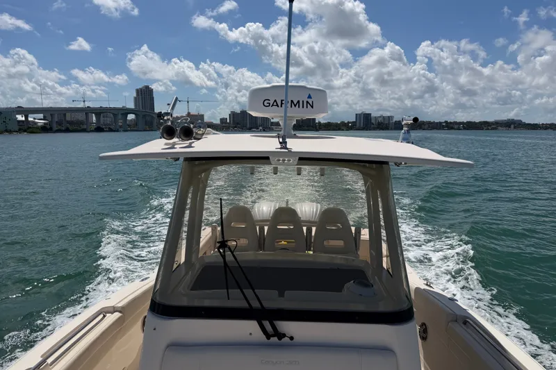 Slide: The Image of 2021 Grady-White Canyon 326 boat cruising on a sunny day with city skyline. - 117