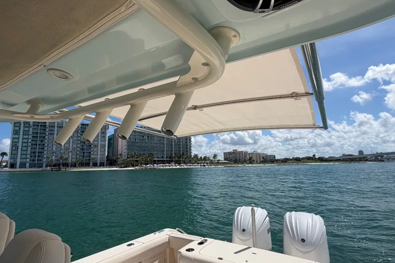 Slide: The Image of 2021 Grady-White Canyon 326 boat on water near coastal buildings under blue sky. - 100