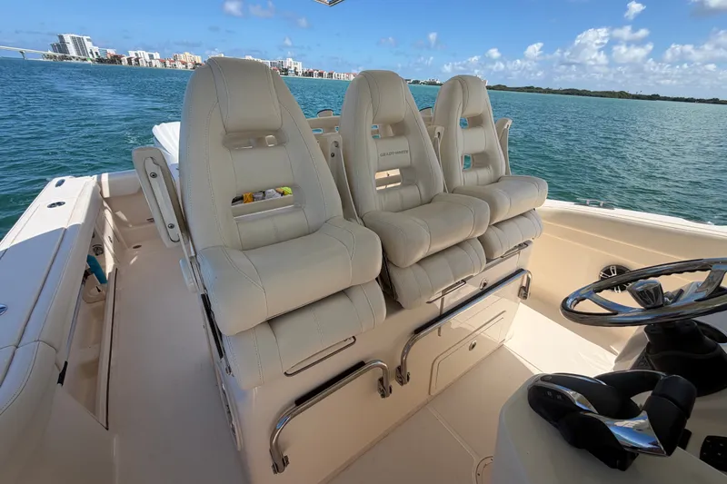 Slide: The Image of 2021 Grady-White Canyon 326 boat interior with luxurious seating and steering wheel. - 86