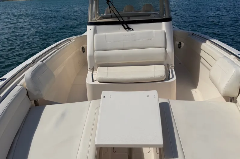 Slide: The Image of 2021 Grady-White Canyon 326 boat interior with white seating and table on water. - 48