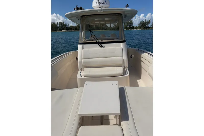 Slide: The Image of 2021 Grady-White Canyon 326 boat interior with seating and table on calm water. - 47
