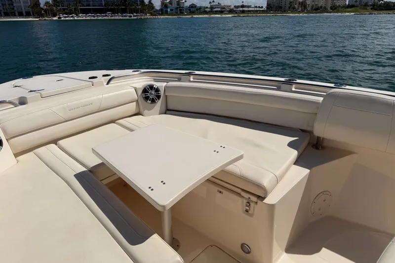 Slide: The Image of 2021 Grady-White Canyon 326 boat interior with seating and table on calm water. - 52