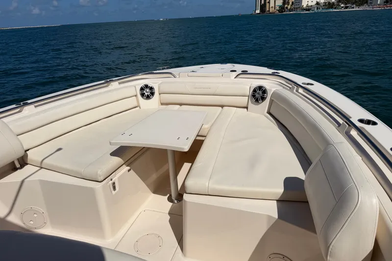 Slide: The Image of 2021 Grady-White Canyon 326 boat interior with seating and table on open water. - 50
