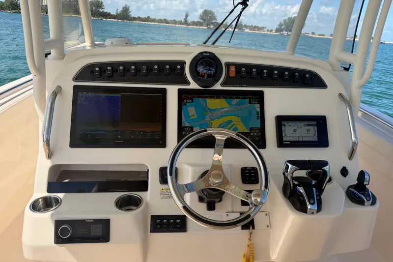 Slide: The Image of 2021 Grady-White Canyon 326 helm with navigation screens and controls on open water. - 65