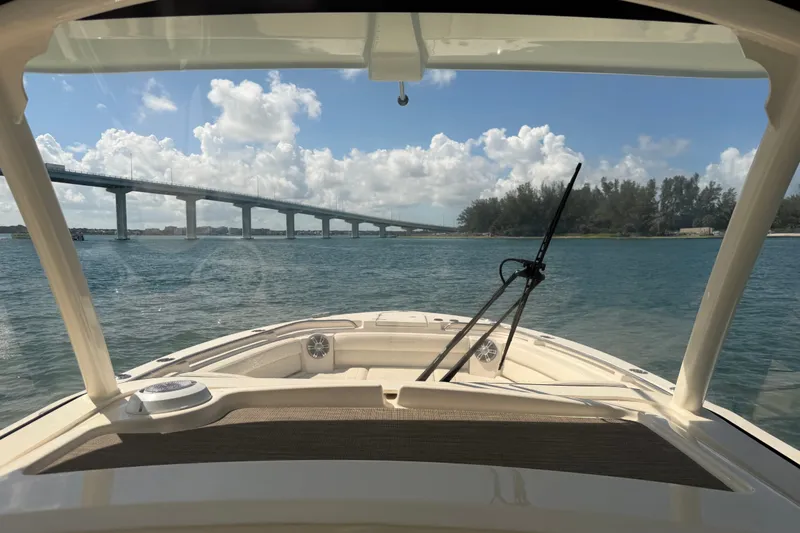 Slide: The Image of 2021 Grady-White Canyon 326 boat cruising under a sunny sky near a bridge. - 75