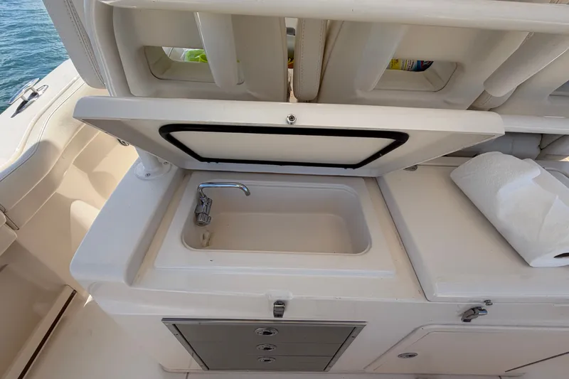 Slide: The Image of 2021 Grady-White Canyon 326 boat sink with faucet and storage compartments. - 90