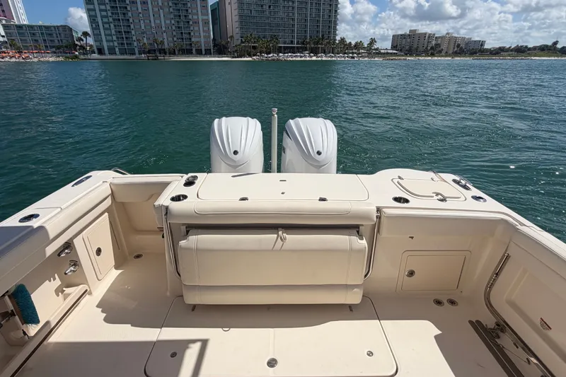 Slide: The Image of 2021 Grady-White Canyon 326 boat interior with dual engines, docked near waterfront buildings. - 61