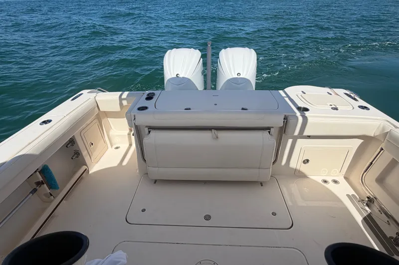 Slide: The Image of 2021 Grady-White Canyon 326 boat deck with twin engines on open water. - 62