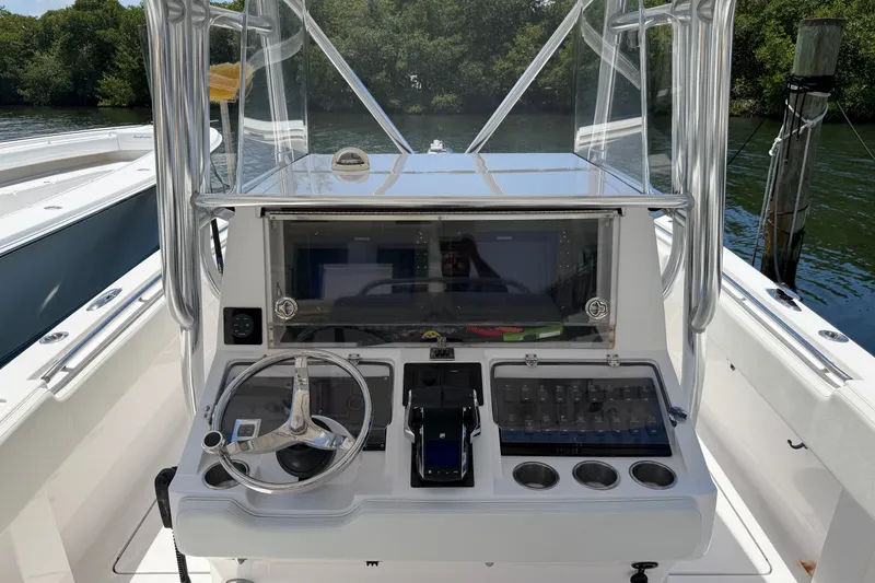 Slide: The Image of 2013 Fountain 34 Center Console boat dashboard with steering wheel and control panel. - 13