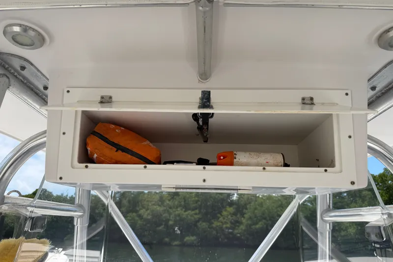 Slide: The Image of Open storage compartment on 2013 Fountain 34 Center Console boat with safety gear. - 22