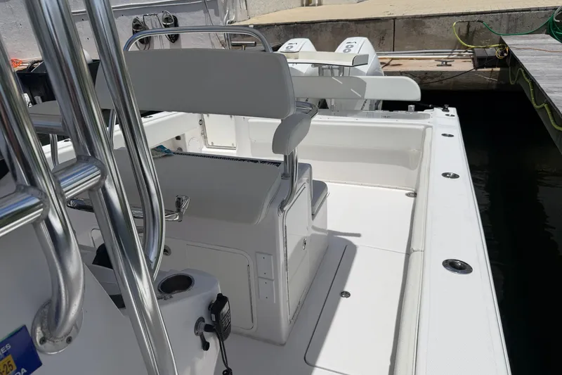 Slide: The Image of 2013 Fountain 34 Center Console boat interior with seating and controls at dock. - 40