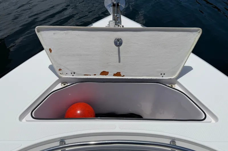 Slide: The Image of Open storage compartment on 2013 Fountain 34 Center Console boat with red buoy inside. - 31