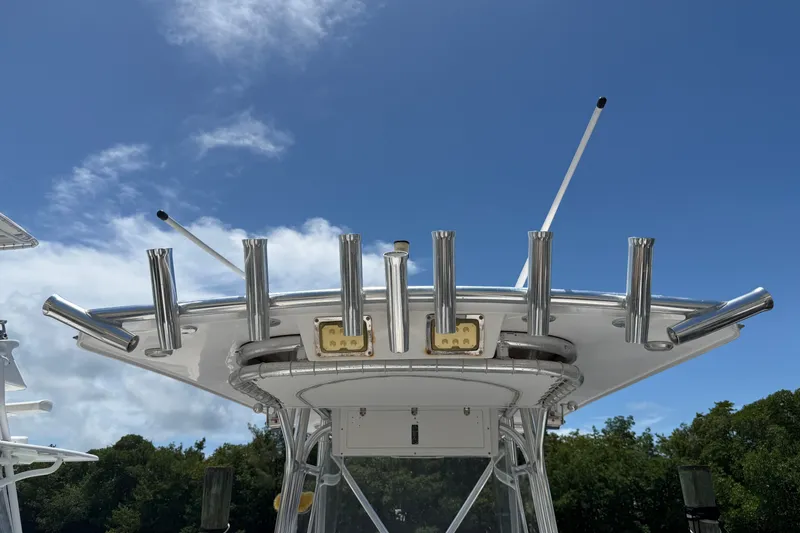 Slide: The Image of 2013 Fountain 34 Center Console boat with rod holders against a clear blue sky. - 18