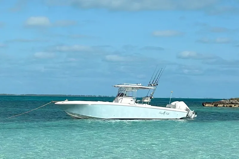 The Image of 2013 Fountain 34 Center Console boat anchored in clear turquoise waters. - 0