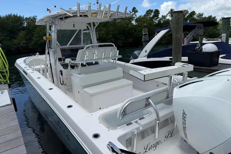 Slide: The Image of 2013 Fountain 34 Center Console boat docked, featuring spacious seating and modern design. - 58