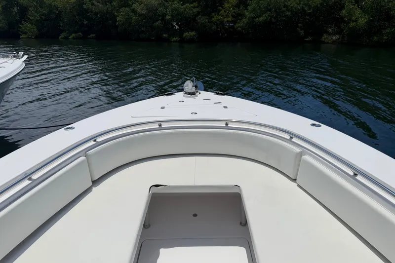 Slide: The Image of 2013 Fountain 34 Center Console boat with white seating, docked on calm water. - 26