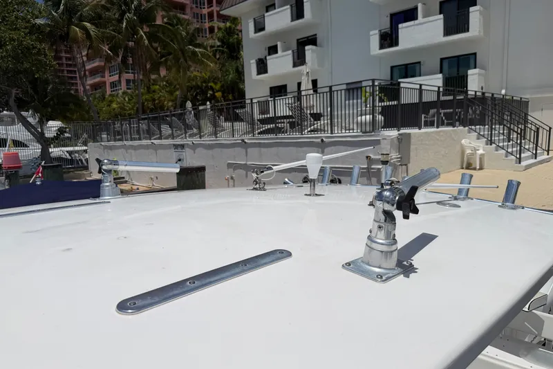 Slide: The Image of 2013 Fountain 34 Center Console boat deck with fishing rod holders, docked near buildings. - 53