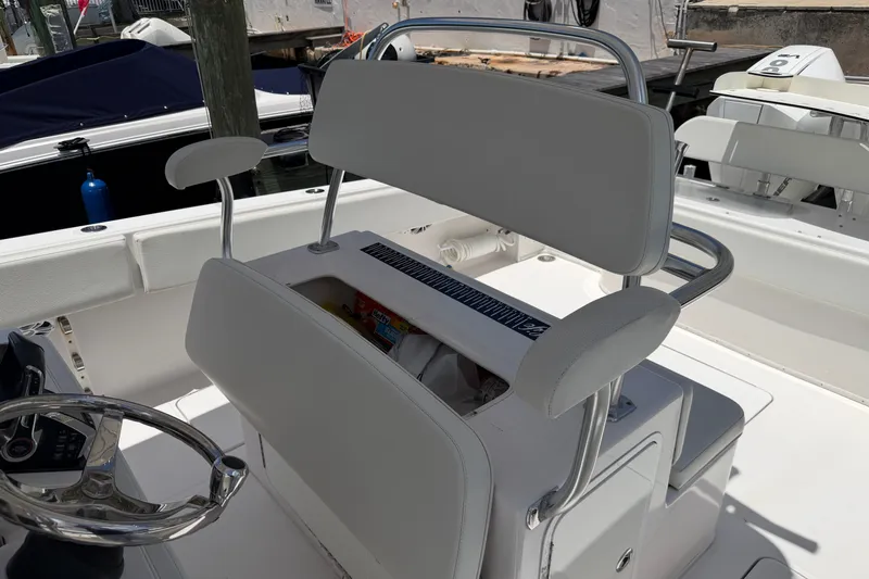 Slide: The Image of 2013 Fountain 34 Center Console boat interior with white seating and steering wheel. - 51
