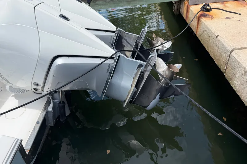 Slide: The Image of Twin outboard motors on a 2013 Fountain 34 Center Console boat docked by the water. - 56