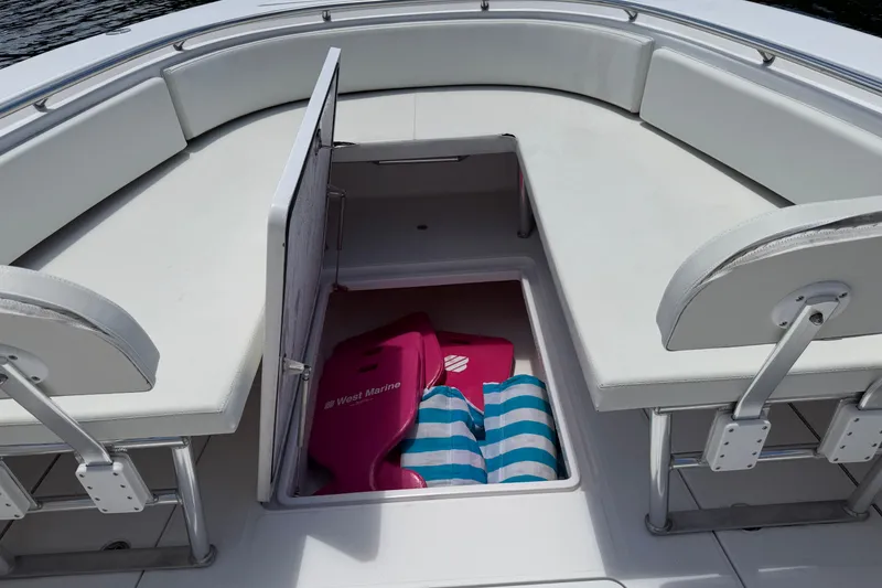 Slide: The Image of 2013 Fountain 34 Center Console boat with open storage compartment and marine gear. - 35