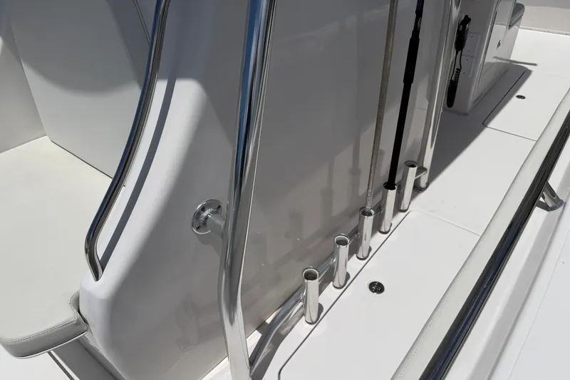 Slide: The Image of 2013 Fountain 34 Center Console boat deck with rod holders and railing. - 38