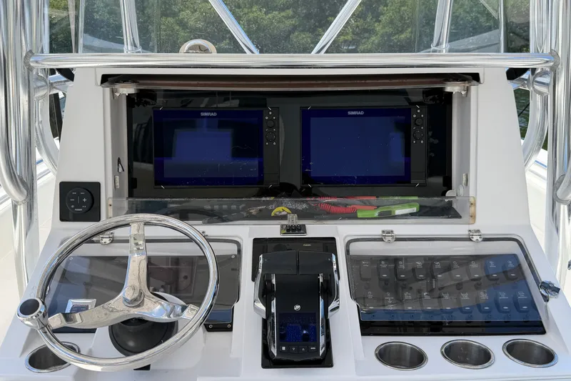 Slide: The Image of 2013 Fountain 34 Center Console dashboard with dual Simrad displays and steering wheel. - 17