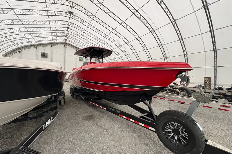 Slide: The Image of Red 2025 Statement 350 Open boat on trailer in covered storage facility. - 2