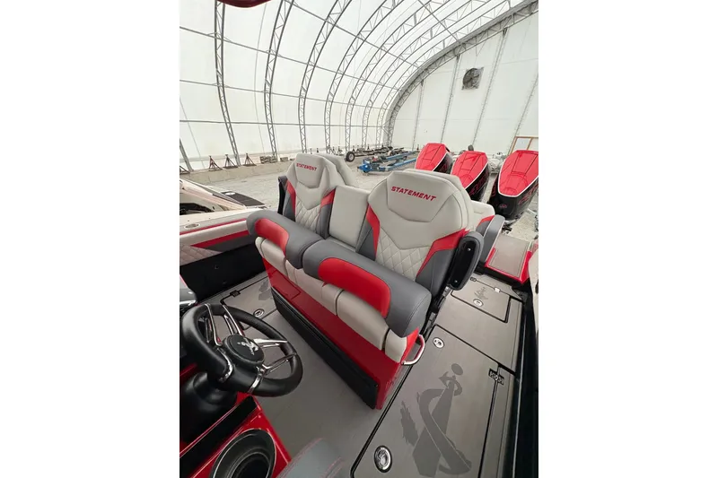 Slide: The Image of 2025 Statement 350 Open boat interior with red and gray seating in a covered storage area. - 6
