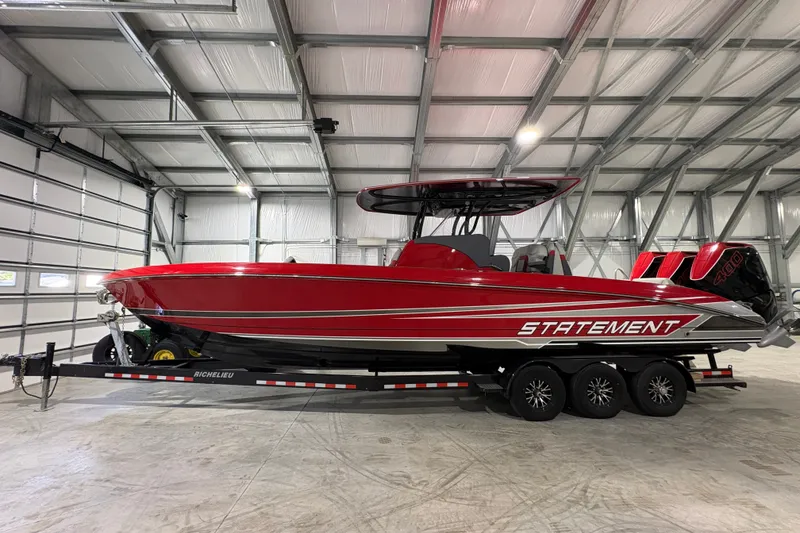 The Image of Red 2025 Statement 350 Open boat on trailer in a spacious garage. - 0