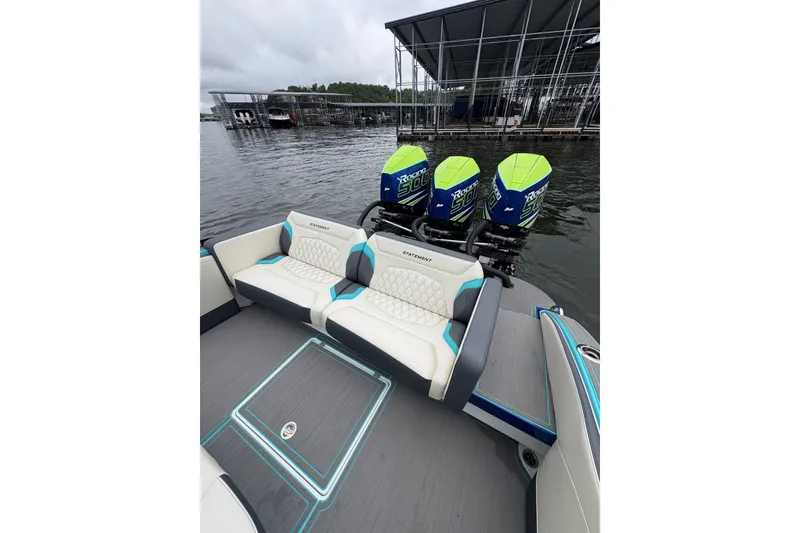 Slide: The Image of 2017 Statement 380 Open boat with triple outboard engines docked by the water. - 14
