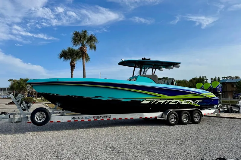 Slide: The Image of 2017 Statement 380 Open boat on trailer, vibrant design, palm trees in background. - 17