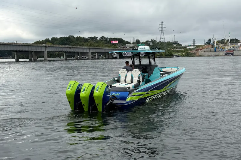 Slide: The Image of 2017 Statement 380 Open boat with triple engines on a calm river near a bridge. - 19