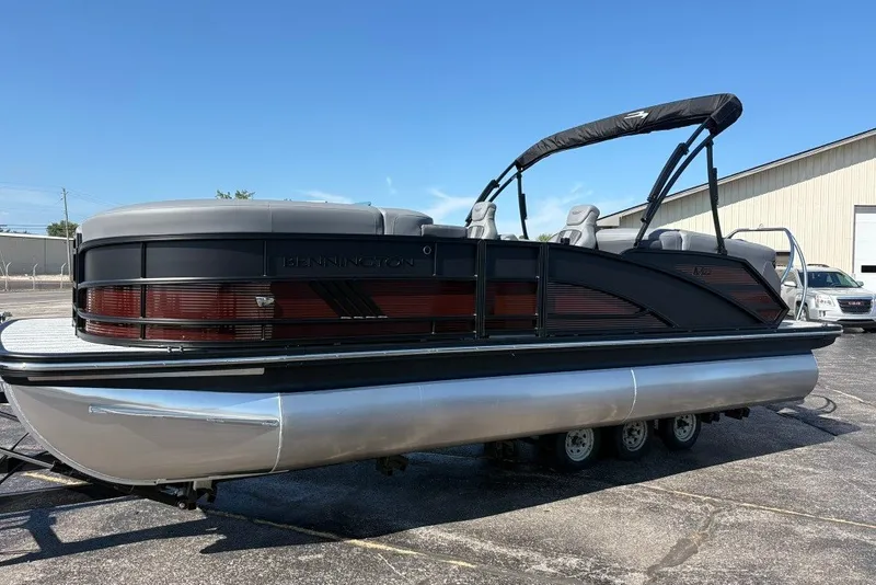 The Image of 2027 Bennington 22 M Open Fastback Quad Bench pontoon boat on display outdoors. - 0