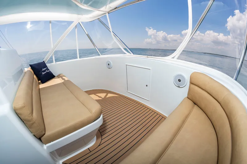 Slide: The Image of The image shows the cockpit of a 2004 Custom Carolina 61' Sportfisherman with beige seating. - 19