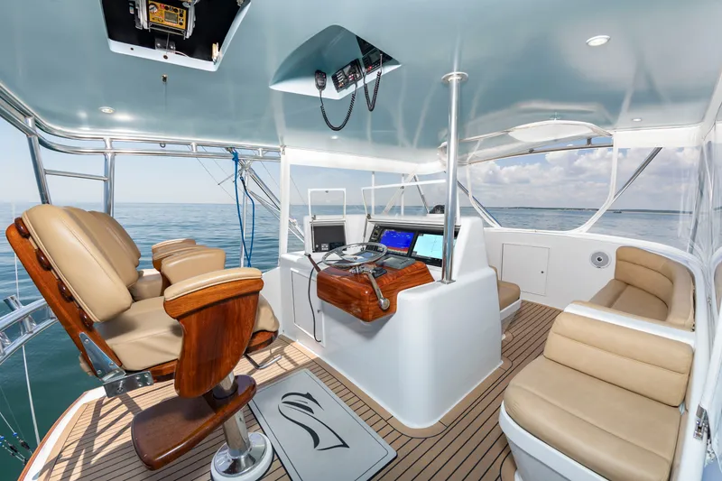 Slide: The Image of The image shows the cockpit of a 2004 Custom Carolina 61' Sportfisherman with luxurious seating and modern electronics. - 14