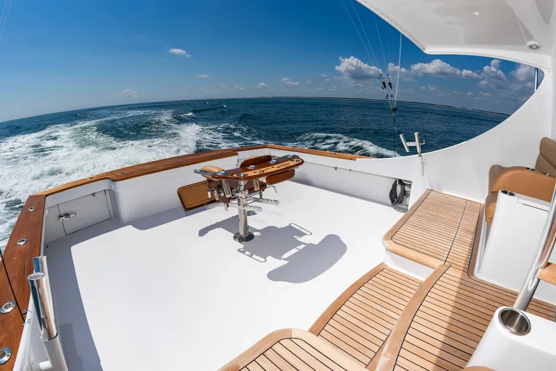 Slide: The Image of The image shows the spacious aft deck of a 2004 Custom Carolina 61' Sportfisherman at sea. - 4