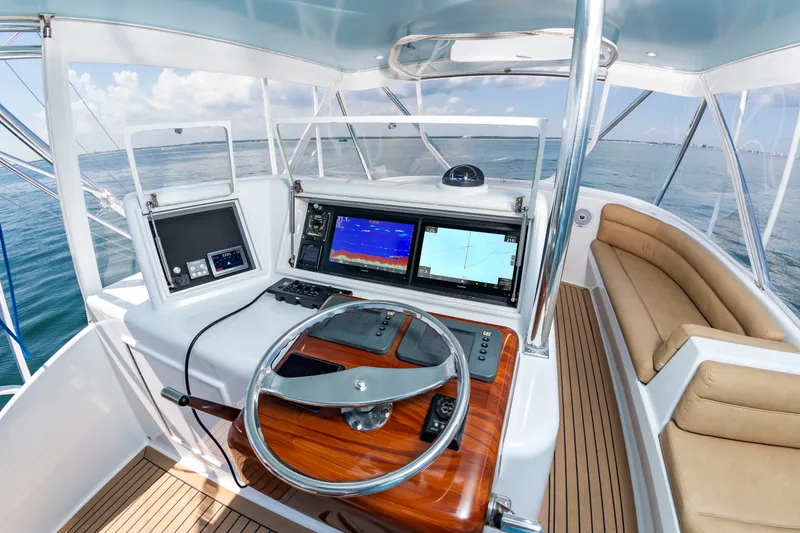 Slide: The Image of The cockpit of a 2004 Custom Carolina 61' Sportfisherman with modern electronics and wood accents. - 16