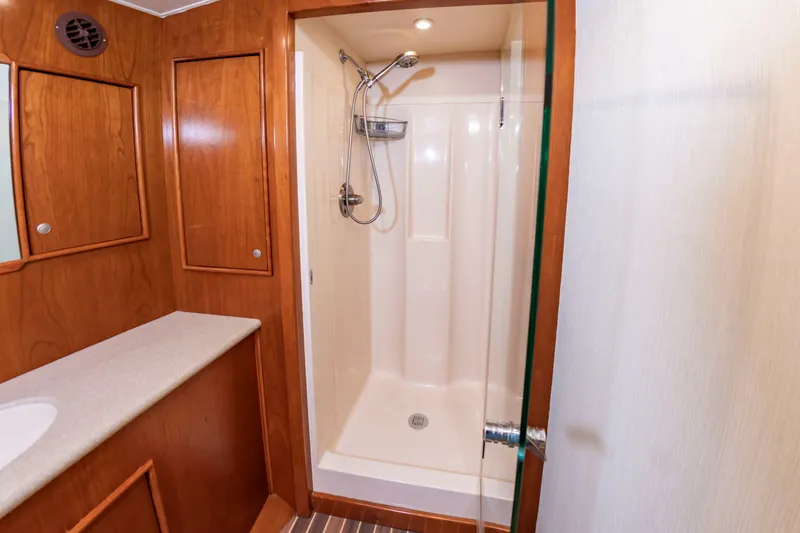 Slide: The Image of A shower stall with a glass wall in a wooden interior, next to a sink with countertop. - 35