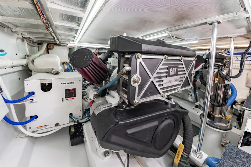 Slide: The Image of The engine room of a 2004 Custom Carolina 61' Sportfisherman features a CAT engine and various equipment. - 51