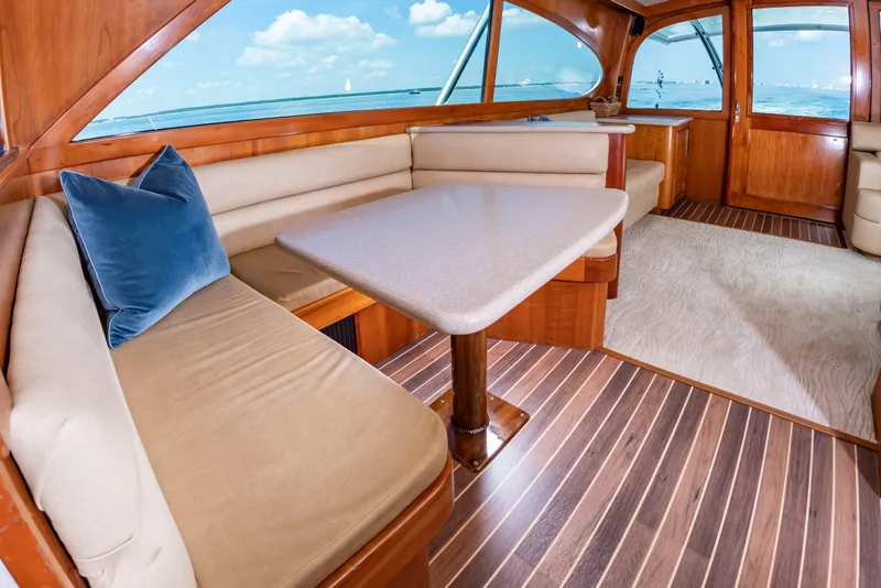 Slide: The Image of The interior of a 2004 Custom Carolina 61' Sportfisherman features an elegant seating area with wood flooring. - 27